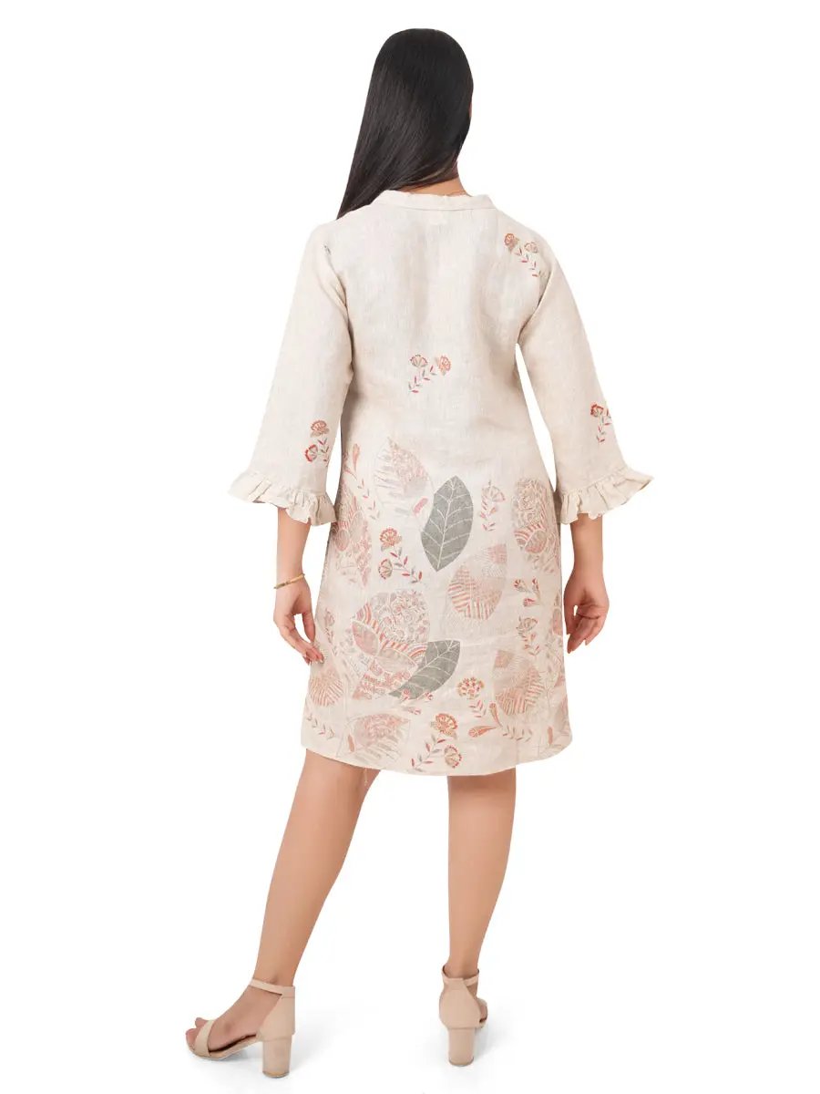 A woman wearing a beige floral linen dress on a white background back view