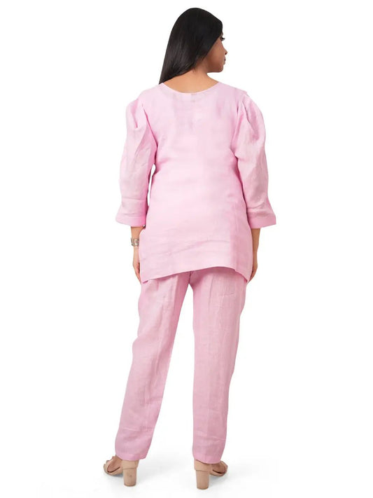 Woman wearing a pink pure linen co-ord on a white background with a back view