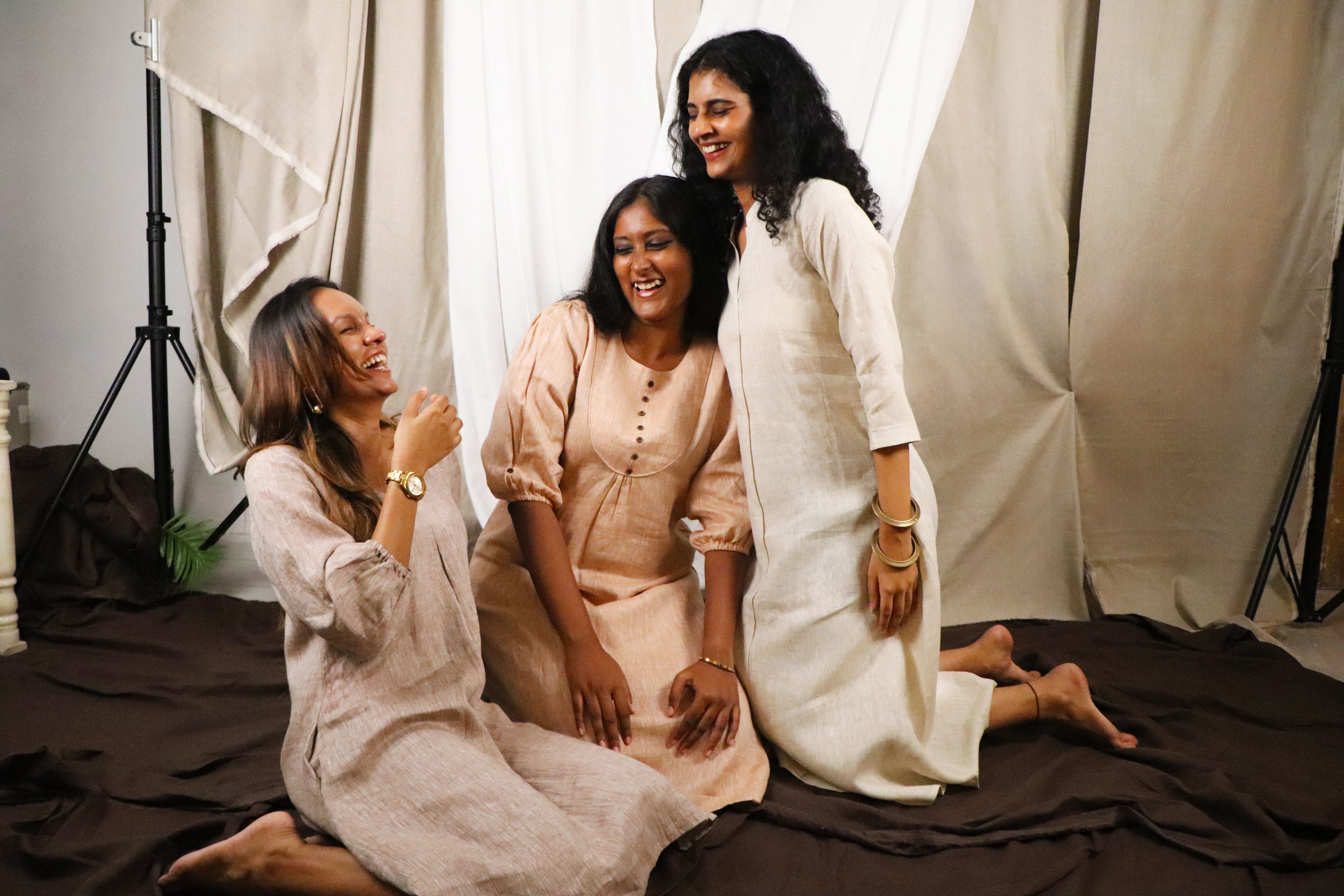 Three women posing together in a photo studio setting.