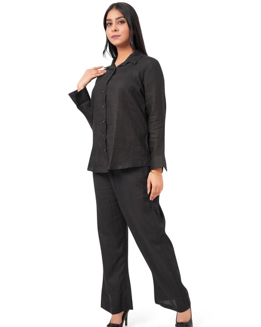 Woman wearing a black linen-co-ord-set on a white background