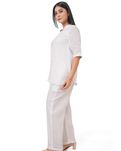 Woman wearing a white linen co-ord set on a white background